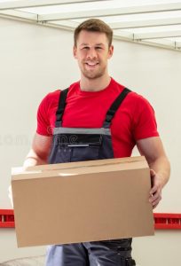 happy male movers holding cardboard boxes young standing moving van 211152207 e1630151990347