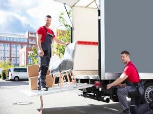 two strong men moving boxes off of a truck into a commercial business relocation orig